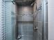 Updated walk-in shower featuring updated tile, a rainfall showerhead and patterned shower door at 3200 W Chenango Ave, Englewood, CO 80110