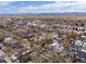 An aerial view shows the neighborhood's homes, tree-lined streets, and surrounding landscape on a partly cloudy day at 4525 N Raleigh St, Denver, CO 80212