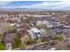 An aerial view displays residential homes, a mix of mature trees, and neighborhood streets on a partly cloudy day at 4525 N Raleigh St, Denver, CO 80212