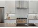 Close-up shot of the gourmet kitchen with stainless steel appliances, white cabinets, and a gas cooktop at 4525 N Raleigh St, Denver, CO 80212