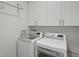 Clean laundry room featuring side-by-side washer and dryer with white cabinetry at 4525 N Raleigh St, Denver, CO 80212