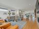 Open-concept living room with wood floors, a sectional sofa, and a view into the stylish kitchen at 4525 N Raleigh St, Denver, CO 80212