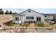 A charming, light-colored home featuring a bay window and a cozy patio area with outdoor seating at 3309 Thornwood Ct, Castle Rock, CO 80108