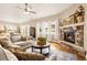 Cozy living room with stone fireplace, plush seating, large windows, and an open floor plan at 3309 Thornwood Ct, Castle Rock, CO 80108