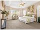 Bright main bedroom featuring tray ceiling, bay window, seating area, and bamboo-style bed frame at 3309 Thornwood Ct, Castle Rock, CO 80108