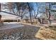 Mature, fully fenced backyard with covered patio, mature trees, and a grassy area at 6851 S Franklin St, Centennial, CO 80122