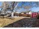 Large, fenced backyard with a covered patio, mature trees, shed, and snow on the ground at 6851 S Franklin St, Centennial, CO 80122