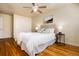 Bright bedroom features hardwood floors, a ceiling fan, and a comfortable bed with decorative pillows at 6851 S Franklin St, Centennial, CO 80122