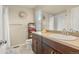 Bright bathroom featuring a sink with dark wood cabinets, a large mirror, and neutral paint at 11235 S Neu Towne Cir, Parker, CO 80134