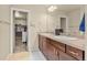 Bathroom featuring a double vanity and a doorway leading to a walk-in closet at 11235 S Neu Towne Cir, Parker, CO 80134