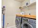 Functional laundry room with modern washer and dryer and shelving at 11235 S Neu Towne Cir, Parker, CO 80134
