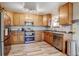 Beautiful kitchen boasts stainless steel appliances, wood cabinets, and wood-look floors at 7245 Prairie Cir, Longmont, CO 80504