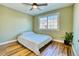 Cozy bedroom showcasing wood floors, ceiling fan, a large window, and ample natural light at 4771 White Rock Cir # C, Boulder, CO 80301