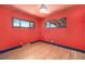 Empty red bedroom with hardwood floors and two windows at 2064 Ironton St, Aurora, CO 80010