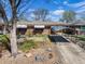Front exterior view of a brick home with a carport, landscaping, and large tree at 2064 Ironton St, Aurora, CO 80010
