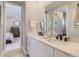 Bathroom featuring a double vanity, modern fixtures, and a view into an adjacent bedroom for added convenience at 1733 Fox Trotter Pt, Castle Rock, CO 80104