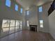 Bright living room with tall ceilings, fireplace, and a sliding glass door to the backyard at 1733 Fox Trotter Pt, Castle Rock, CO 80104