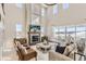 Bright, open living room featuring a cozy fireplace, large windows, and comfortable seating area at 1733 Fox Trotter Pt, Castle Rock, CO 80104