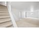 A finished basement features neutral carpet, white walls and a staircase at 3930 S Spruce St, Denver, CO 80237