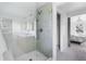 Bathroom featuring a tiled glass shower with a seating area and a glimpse into an adjacent bedroom at 3930 S Spruce St, Denver, CO 80237