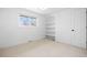 Bedroom with a cozy carpet and a window offering scenic views, complemented by built-in shelving for storage at 3930 S Spruce St, Denver, CO 80237