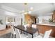 Bright open-concept dining room featuring modern lighting, dining table, and an adjacent kitchen and living area at 3930 S Spruce St, Denver, CO 80237