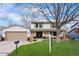 Charming two-story home featuring a well-manicured lawn, double front doors, and attached two-car garage at 3930 S Spruce St, Denver, CO 80237