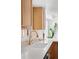 Bright kitchen featuring wooden cabinets, quartz countertops, and a modern gold faucet at 3930 S Spruce St, Denver, CO 80237