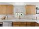 Charming kitchen with wooden cabinets, white countertops, and a view from the window at 3930 S Spruce St, Denver, CO 80237