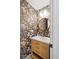 Stylish powder room featuring a unique wallpaper design, a modern sink, and elegant fixtures at 3930 S Spruce St, Denver, CO 80237