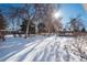 Snowy backyard with mature trees and a wooden gazebo at 900 Emerald St, Broomfield, CO 80020