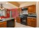 Kitchen with granite countertops, wood cabinets, and black appliances at 900 Emerald St, Broomfield, CO 80020