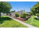 Well-maintained building exterior complemented by lush landscaping, brick accents, and a manicured lawn at 10150 E Virginia Ave # 7-302, Denver, CO 80247