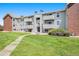 Multi-story apartment building featuring balconies, green lawn and brick accents at 10150 E Virginia Ave # 7-302, Denver, CO 80247