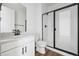 Modern bathroom with white vanity, black hardware and a frameless glass shower at 25323 E Warren Pl, Aurora, CO 80018