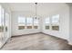 Bright dining room with modern chandelier, large windows, and wood-look flooring at 25323 E Warren Pl, Aurora, CO 80018