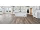 Open-concept kitchen with island, white cabinets, and hardwood flooring connects to the dining area at 25323 E Warren Pl, Aurora, CO 80018