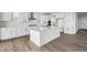 Modern kitchen featuring white cabinets, stainless steel appliances, an island, and hardwood floors at 25323 E Warren Pl, Aurora, CO 80018