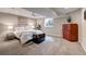 Inviting bedroom with soft carpet, neutral walls, cozy lighting, and a charming vintage trunk for a warm, relaxing ambiance at 5745 W Mansfield Ave # 265, Denver, CO 80235