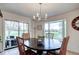 Bright dining room with views, an oval table, chandelier, and a sliding door leading to a patio at 5745 W Mansfield Ave # 265, Denver, CO 80235