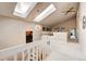 Well-lit hallway featuring vaulted ceilings, skylights, and neutral paint creating an airy and spacious transition space at 5745 W Mansfield Ave # 265, Denver, CO 80235
