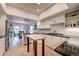 A modern kitchen featuring white cabinets, black countertops, stainless steel appliances, and hardwood floors at 5745 W Mansfield Ave # 265, Denver, CO 80235