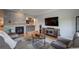 Stylish living room with a fireplace, bar area, wooden floors, and comfortable seating at 5745 W Mansfield Ave # 265, Denver, CO 80235