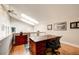 Home office with vaulted ceilings, skylights, hardwood floors, and a custom desk creating an inviting workspace at 5745 W Mansfield Ave # 265, Denver, CO 80235
