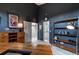 Well-lit office space with dark blue walls, built-in shelving, and a view to a bedroom and bathroom at 5745 W Mansfield Ave # 265, Denver, CO 80235