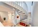 Open layout showing a winding staircase adjacent to hardwood floors, with sightlines to multiple rooms at 5745 W Mansfield Ave # 265, Denver, CO 80235