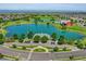 Panoramic aerial shot highlights a community with lakes, a red barn, and amenities, offering a serene environment at 18085 E 107Th Pl, Commerce City, CO 80022