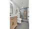 Well-lit bathroom featuring a modern vanity, gray tile floor, and a luxurious walk-in shower at 18085 E 107Th Pl, Commerce City, CO 80022