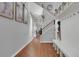 Bright hallway with hardwood floors, white bench, and a staircase with wood and iron railing at 18085 E 107Th Pl, Commerce City, CO 80022