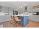 Bright kitchen with island, gray cabinets, stainless appliances, and pendant lights at 18085 E 107Th Pl, Commerce City, CO 80022